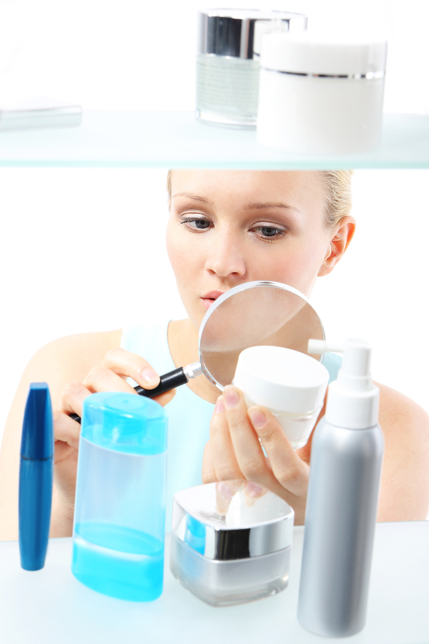 A woman stands at the client shelf and looks at the composition of creams